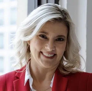 Deora, professional franchise consultant smiling confidently in a red blazer