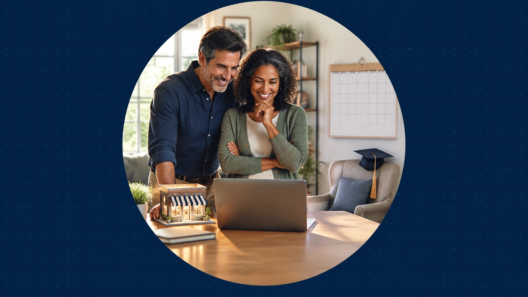 An empty-nester couple smiles at a laptop beside a miniature storefront and a blank wall calendar